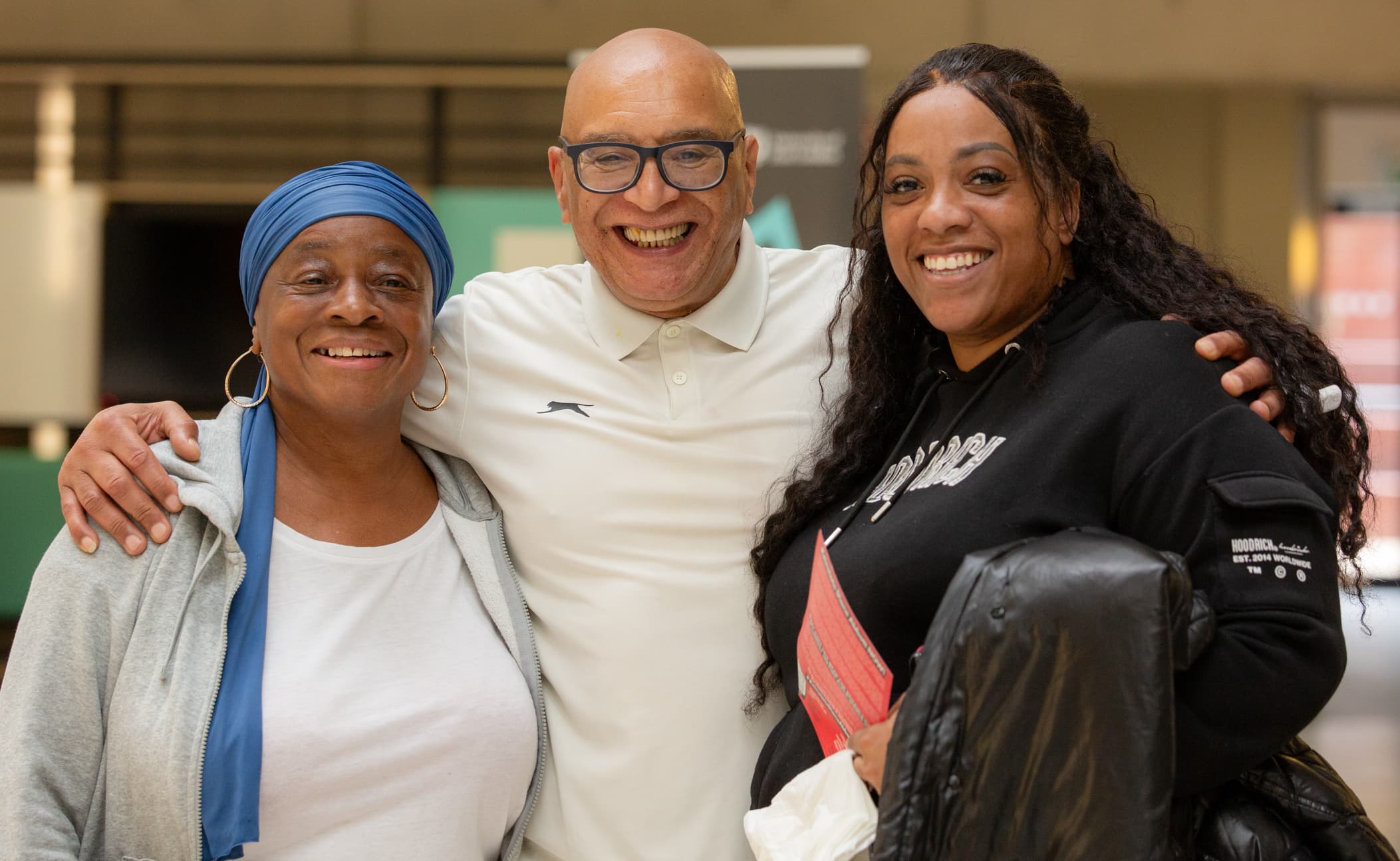 Three attendees smiling with their arms around each other in the foyer at an APA conference