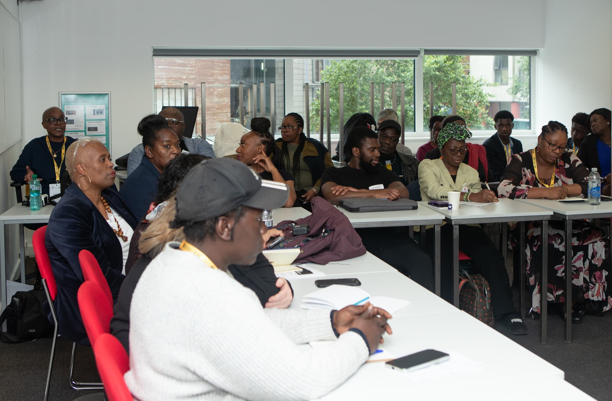 A full workshop room of participants seated around tables, listening to a discussion at an APA conference